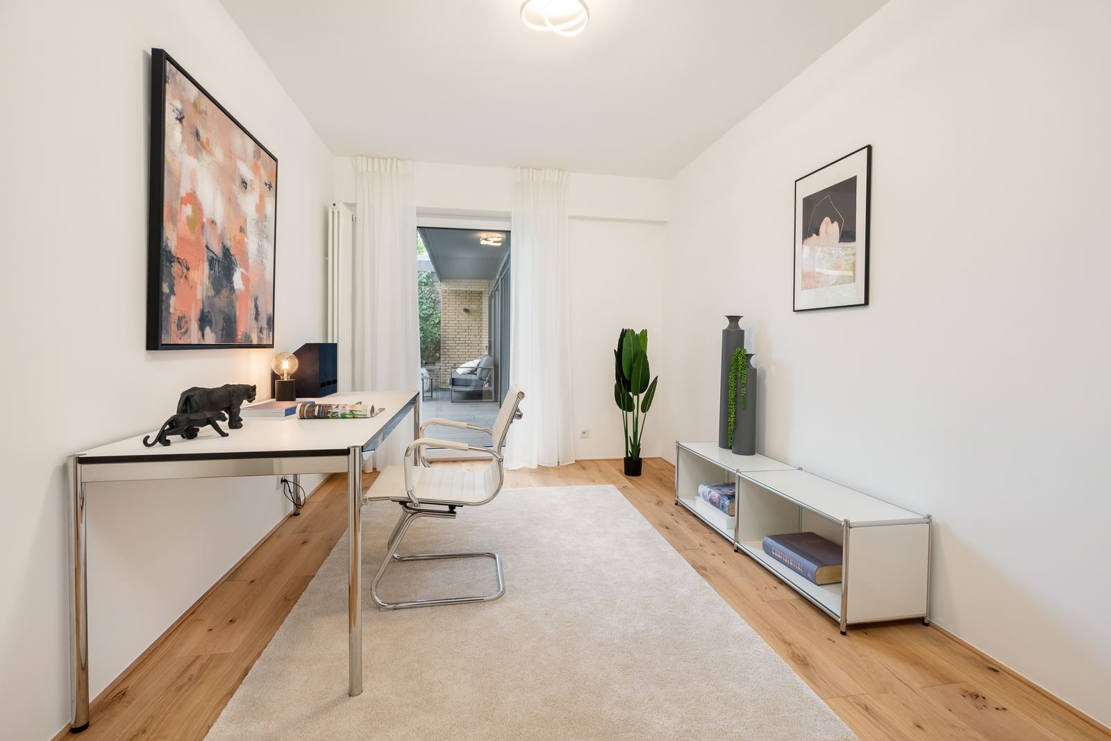 Arbeitszimmer mit Schreibtisch und Blick in den Garten