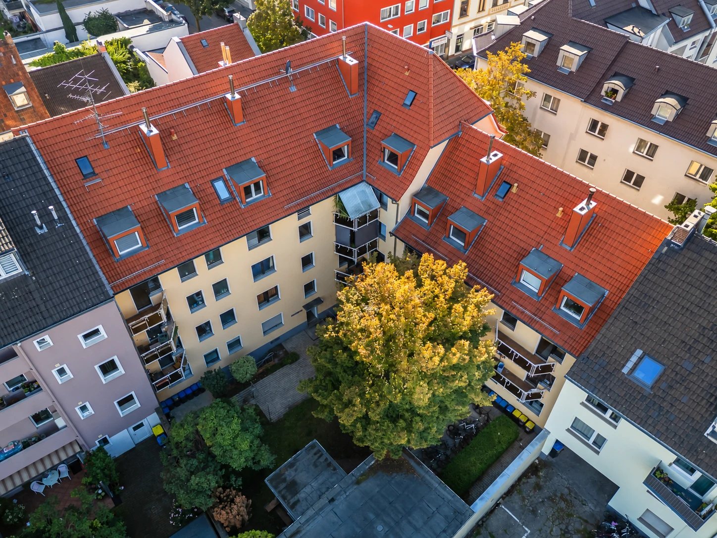 Wohnanlage mit Innenhof und großem Baum, von oben gesehen