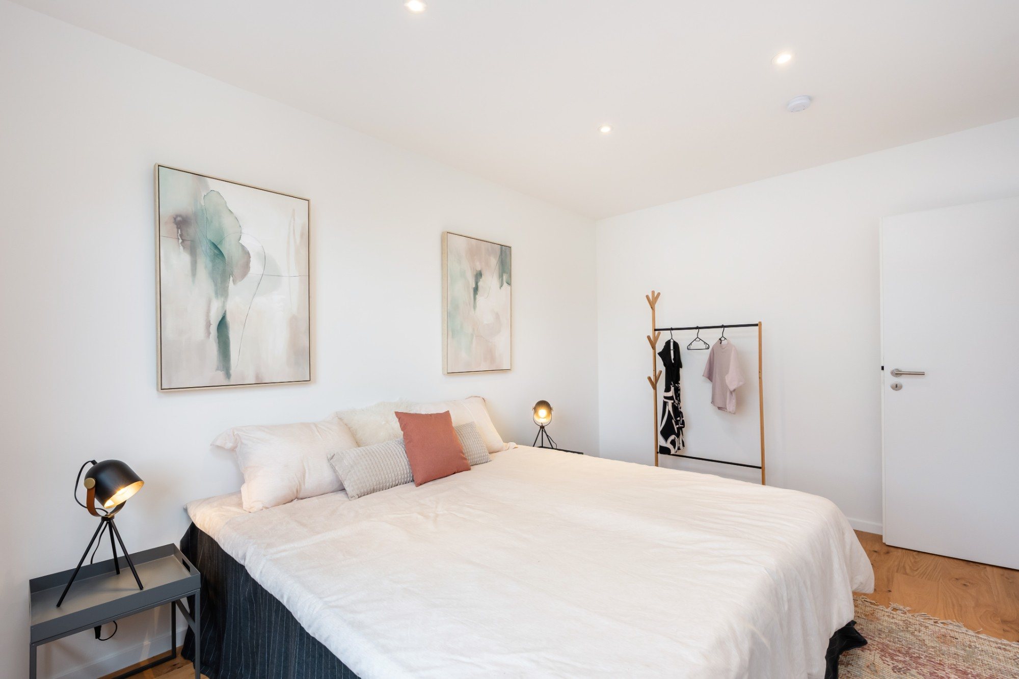 Schlafzimmer mit Doppelbett und zwei großen Bildern an der Wand