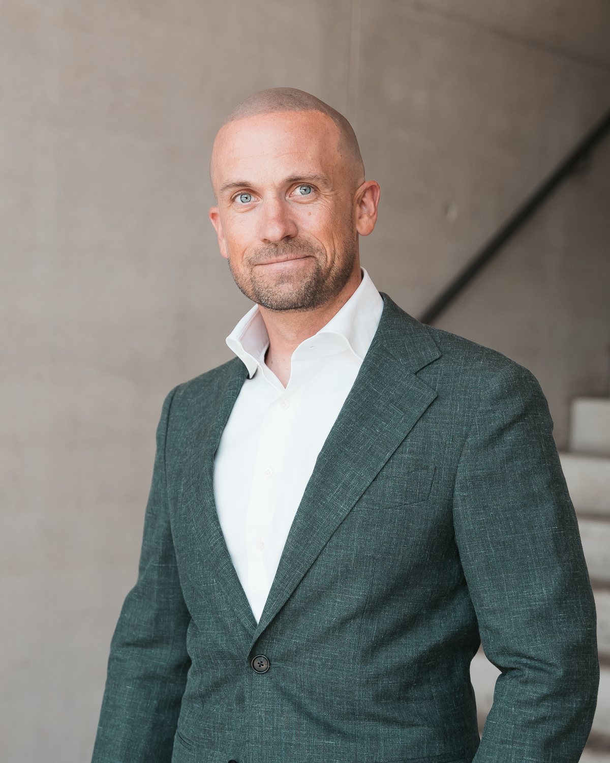 Jan Philipp Thier, Geschäftsführer, im grünen Anzug vor einer Betontreppe