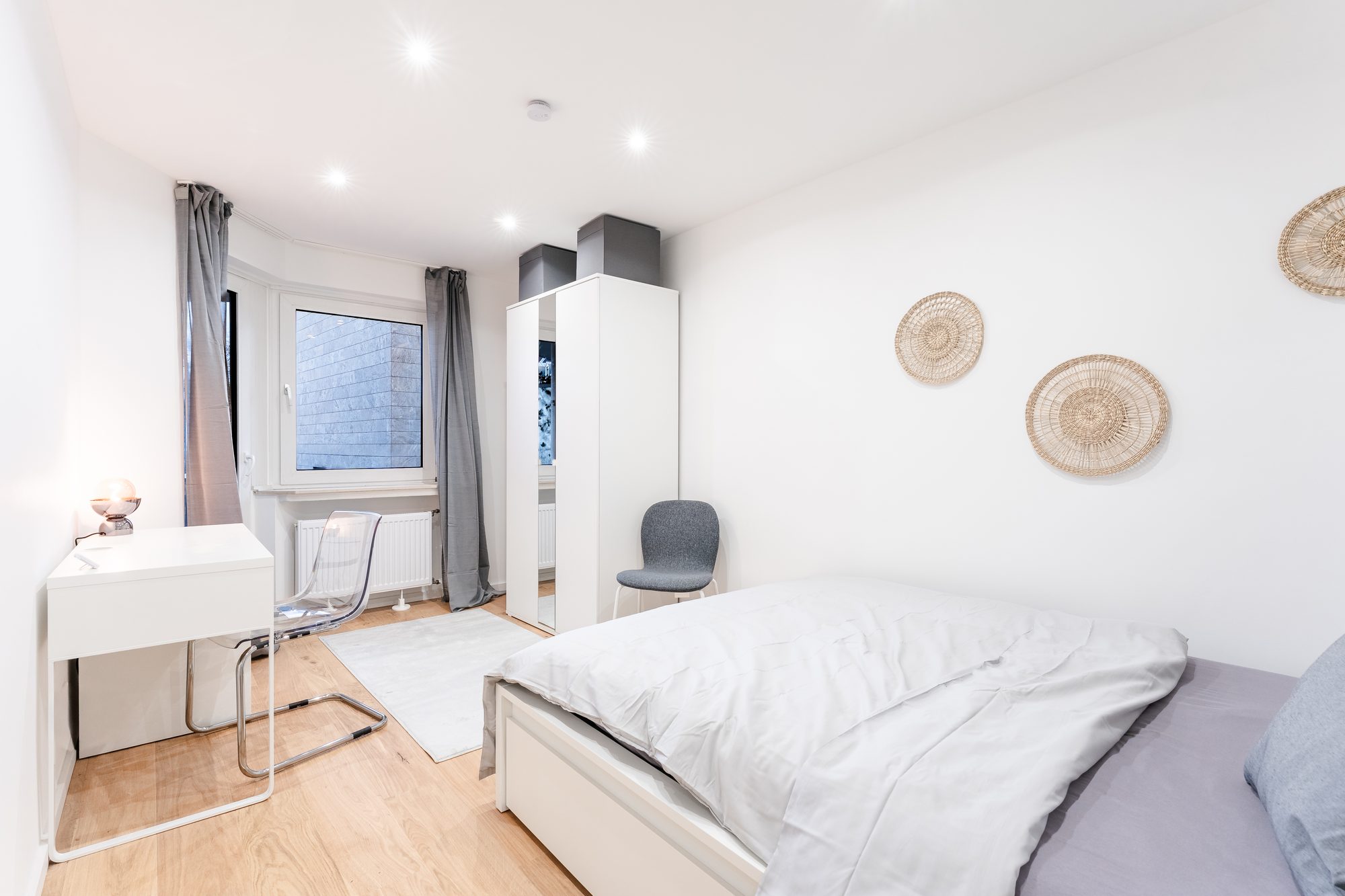 Möbliertes Zimmer mit Bett, Schreibtisch und Kleiderschrank